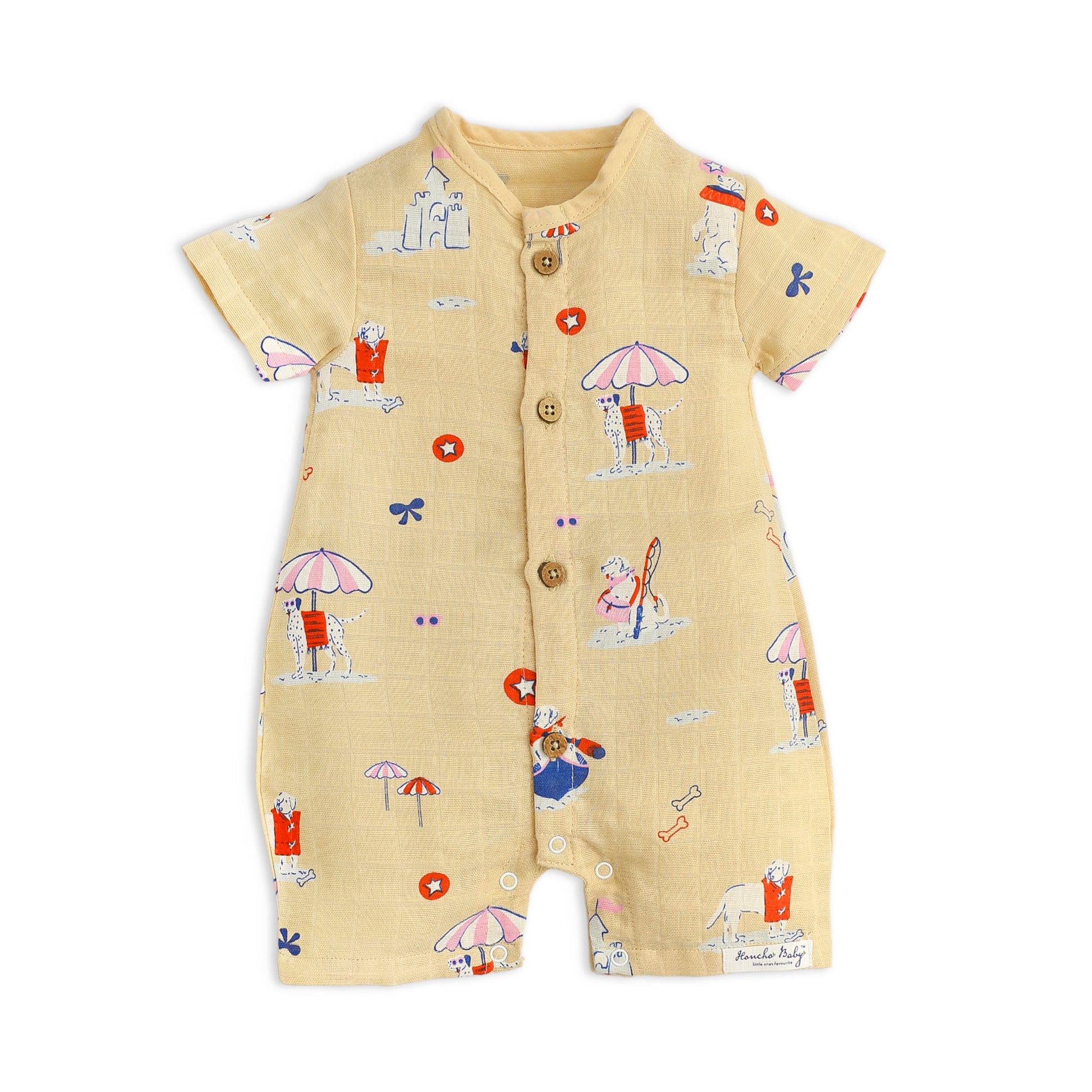 Organic muslin baby romper with dog print at beach- front view showing button closure and short sleeves