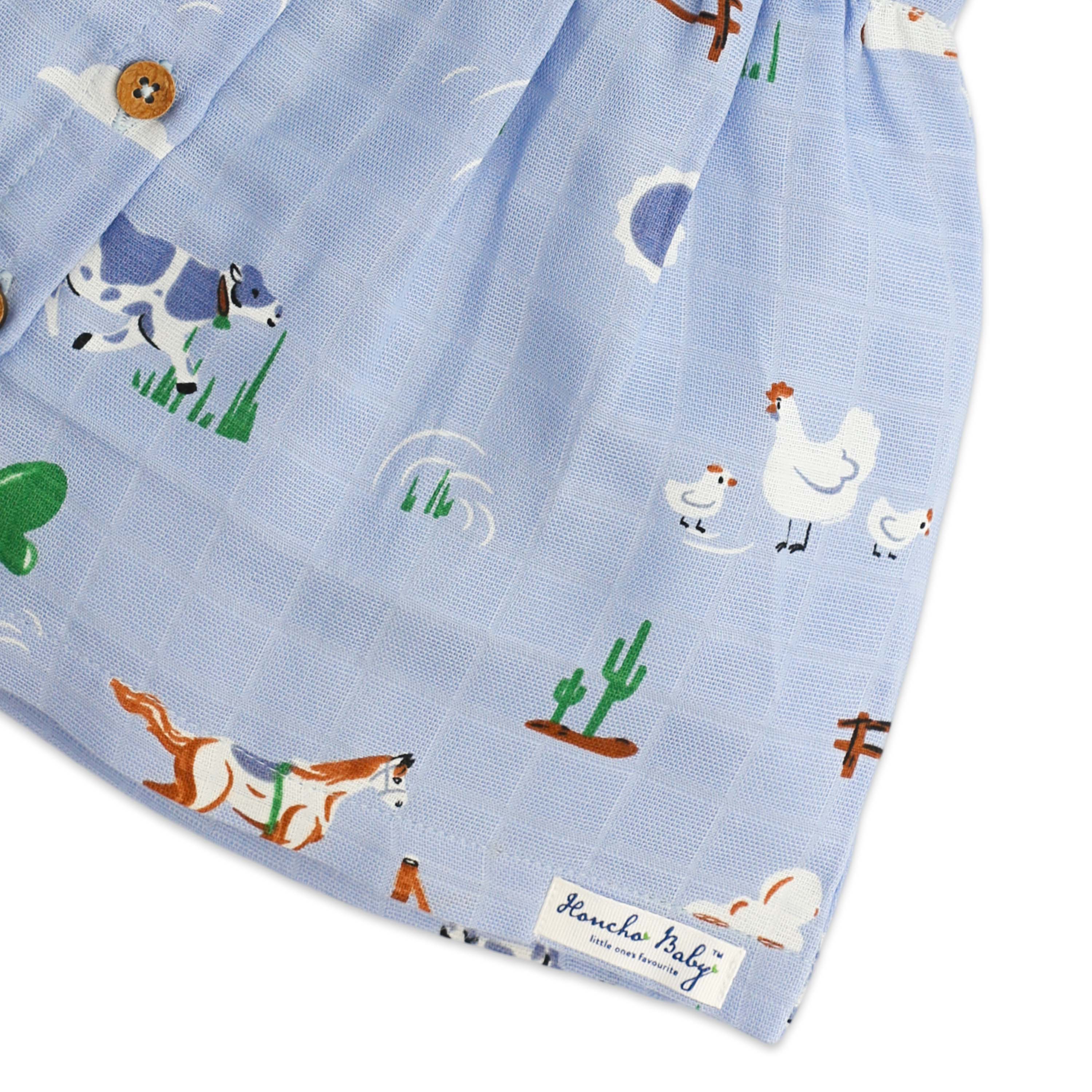 Girls frock with farm animal patterns on a blue background, featuring cows, chickens, and dogs with honcho baby label.