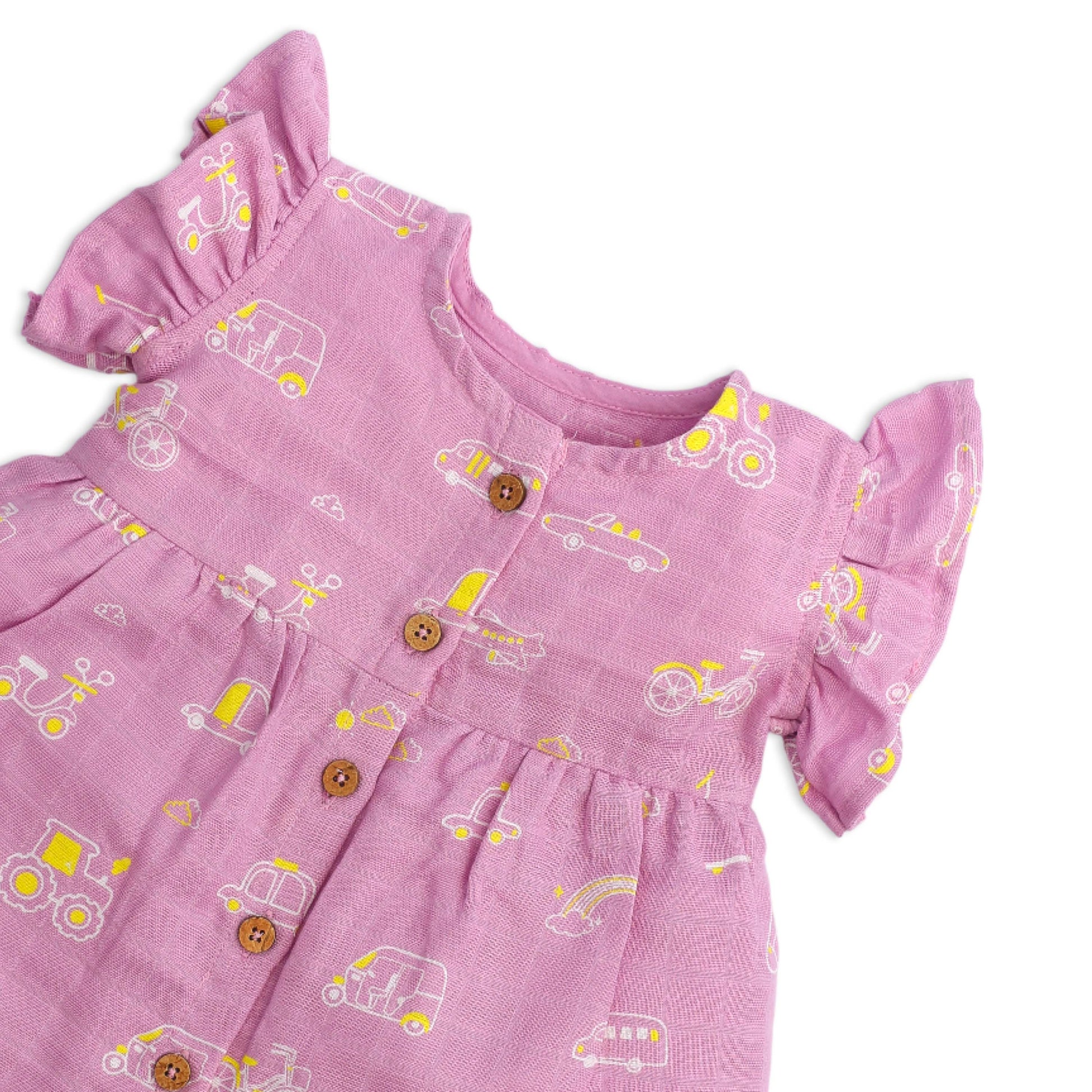 Close-up of coconut shell buttons and soft muslin cotton fabric texture on baby frill sleeve dress