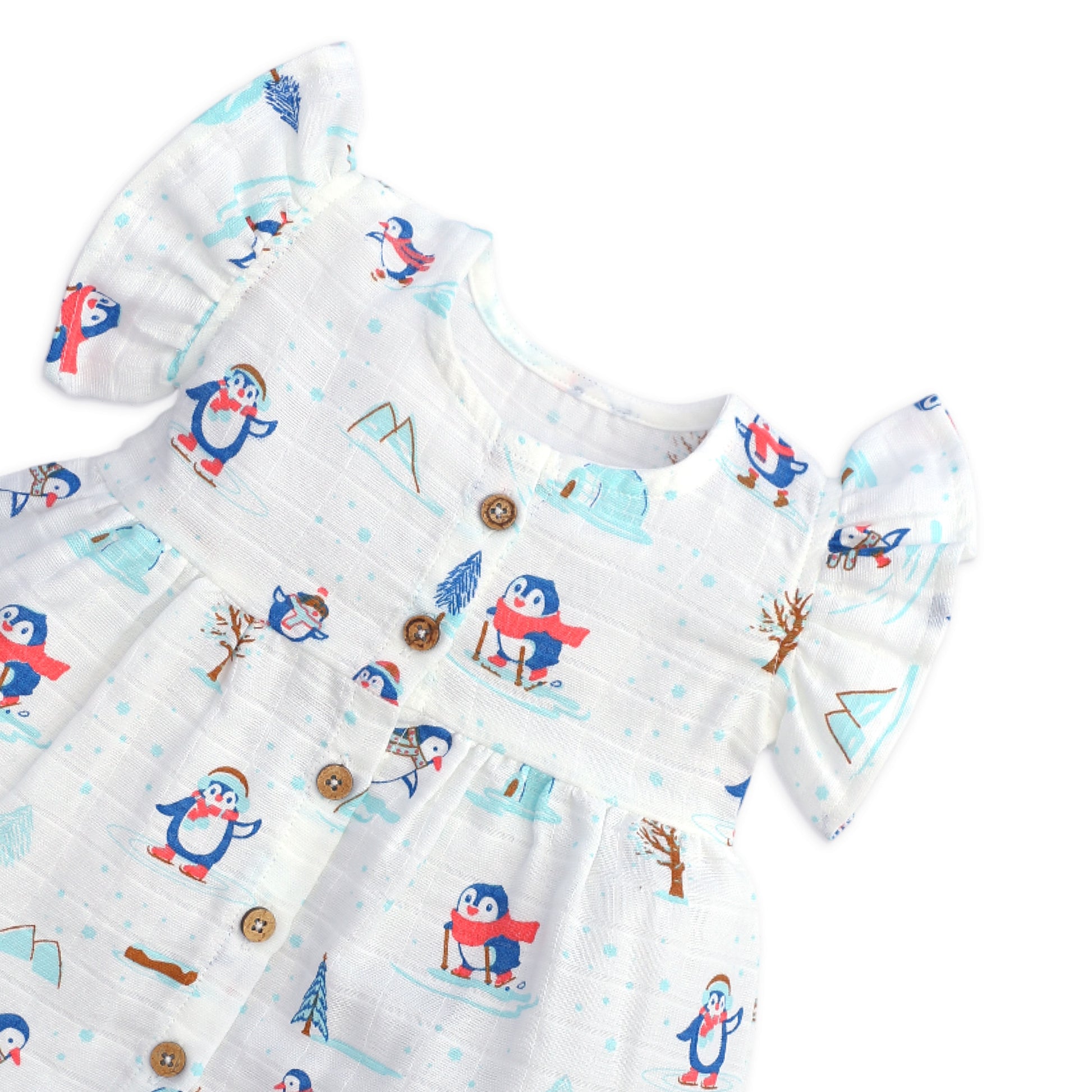 Close-up of coconut shell buttons and soft muslin cotton fabric texture on baby frill sleeve dress