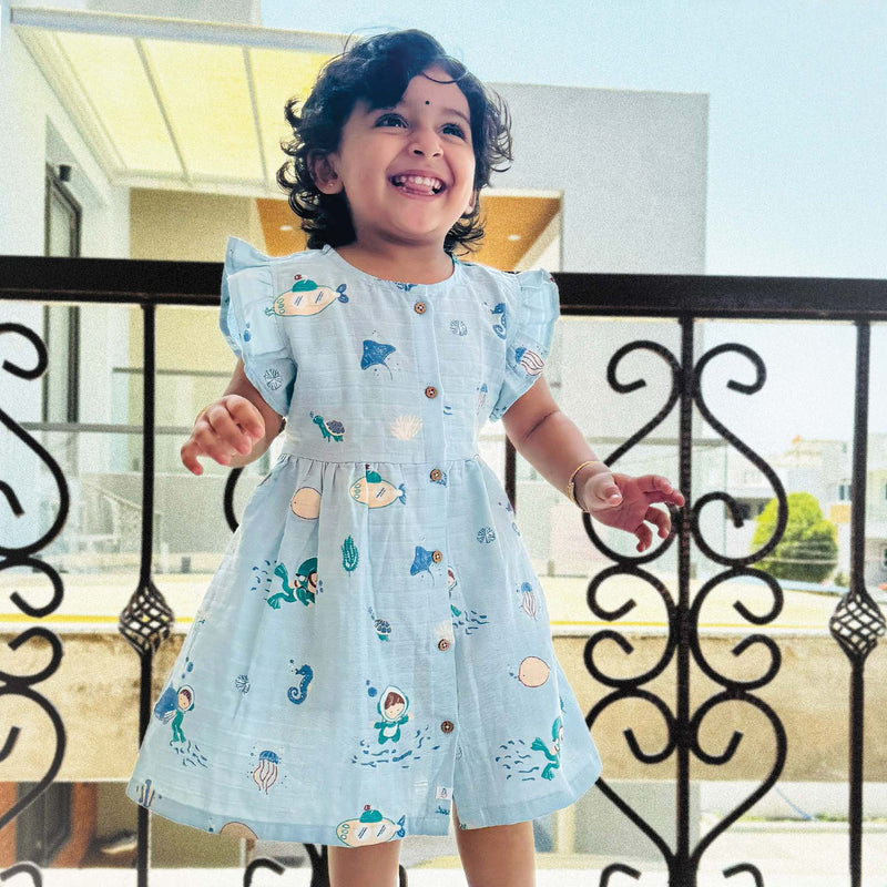 Buy baby girl frocks online with ocean-themed print online.